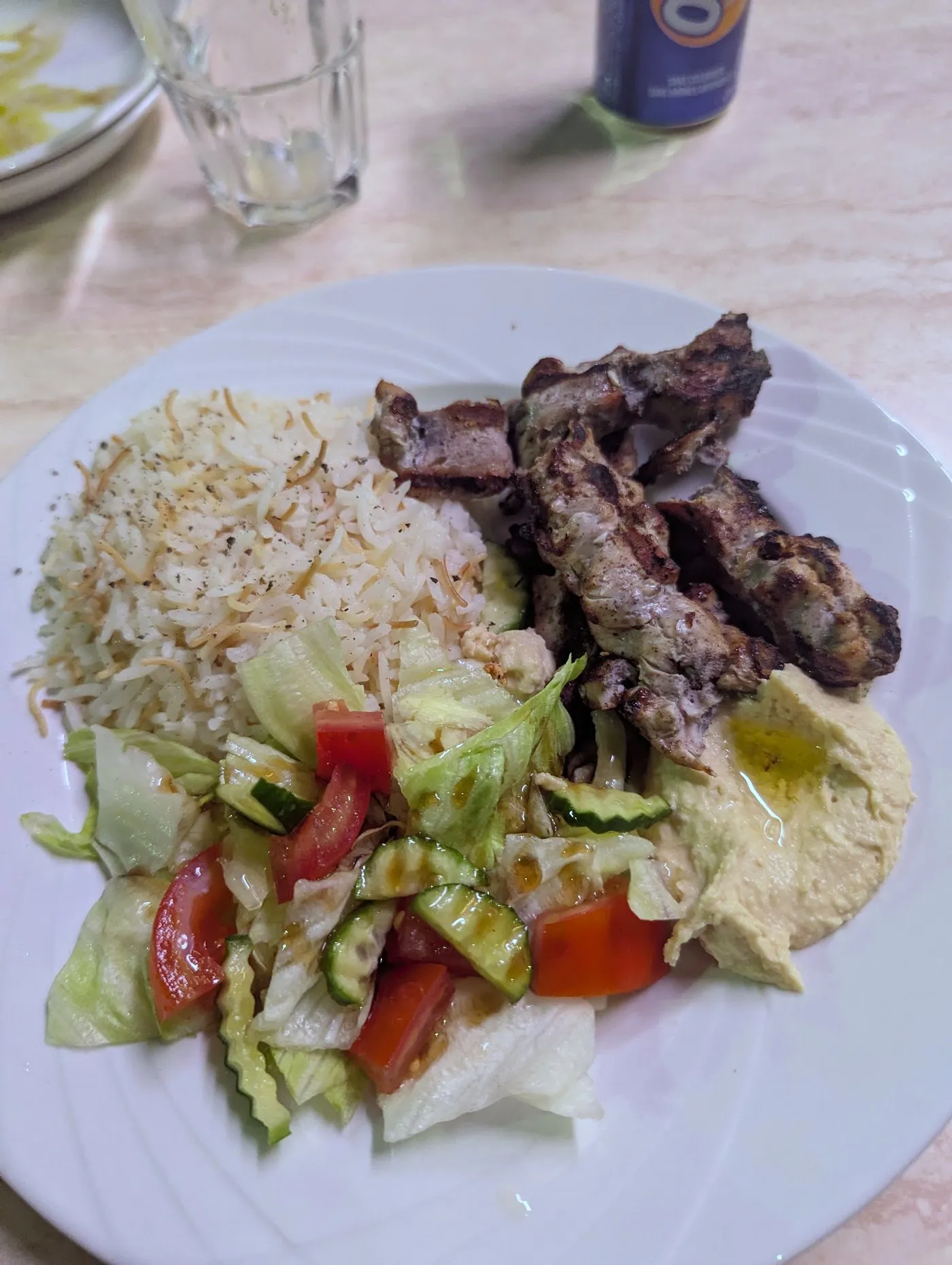 Assiette de brochettes marinées, riz aux vermicelles, houmous et salade